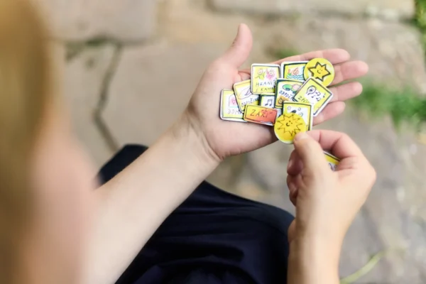 Dětská dlaň drží několik magnetek Caromat hvězdičky pro děti.