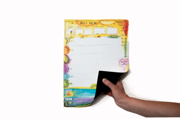 Magnetická barevná deska pro děti Caromat ohnutá v ruce, ukazující flexibilní materiál.